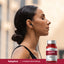 A young adult woman with her eyes closed, wearing earbuds, sits beside a 5-HTP supplement bottle.