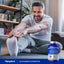 A man stretches on a yoga mat with a Glucosamine Chondroitin bottle beside him, conveying a healthy lifestyle choice.