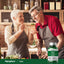 Senior couple in kitchen; woman offers man a spoonful of greens next to a Zinc bottle.