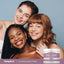 Three young women smiling, holding a jar of Collagen Placenta Cream.