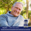 A senior man smiling outdoors next to a bottle of Diabetic Health Formula.