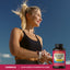 An adult woman checks her smartwatch post-exercise, next to a bottle of Glucosamine.