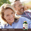 Woman smiling and man laughing outdoors, enjoying time together with an Irish Sea Moss bottle visible.