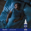 A young man sleeping in bed with a bottle of Liquid Melatonin on the bedside table, indicating its use as a sleep aid.