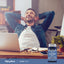 A smiling man relaxes at his desk with hands behind his head, next to a bottle of Lutein 40MG with Zeaxanthin.