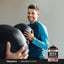 A smiling man exercises with medicine balls near a Mega Multi for Men bottle, showcasing a healthy lifestyle.