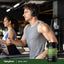 Lifestyle image of two adults exercising on treadmills at a gym with a Piping Rock Royal Jelly 2500 mg supplement bottle displayed in the bottom right corner