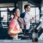 Adult woman and adult man running on treadmills at a gym with Piping Rock Chelated Multi Minerals Full Spectrum bottle displayed in the foreground.