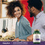 Young couple talking in a kitchen with a Colon Cleansing Formula bottle on the counter.