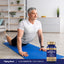Middle-aged man stretching on a yoga mat next to a bottle of Quercetin + Zinc Complex.