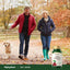 Middle-aged man and woman walk a golden retriever on an autumn path, next to an Ultra Tart Cherry bottle.