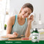 Young woman enjoys cereal with a spoon next to a Wormwood bottle, creating a lifestyle scene.